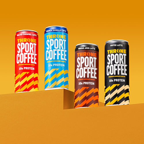 Four vibrant cans of Mocha Java Latte by Throne Sport Coffee are displayed on orange geometric platforms against a yellow background. Enriched with lactose free milk, this protein coffee is perfect for active lifestyles and stands out with its bold, colorful packaging.