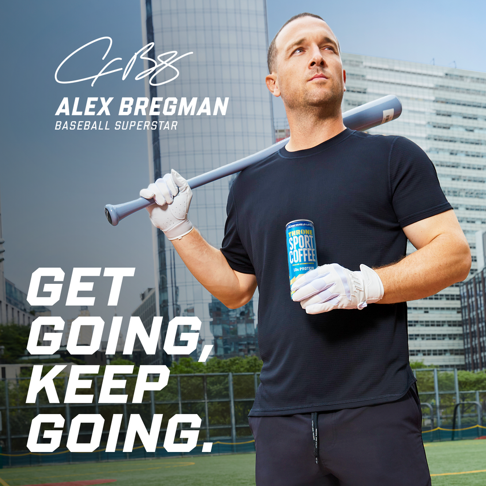 A baseball player holding a bat and a can of French Vanilla Latte protein coffee, standing on a field with city buildings behind him. Text: GET GOING, KEEP GOING. Alex Bregman, Baseball Superstar.